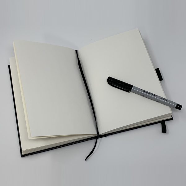A black SMALL JOURNAL - KING HOOT with a pen and a black pen.