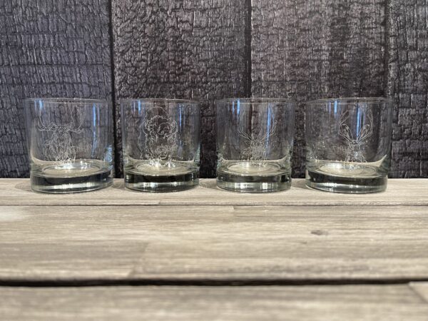 A set of four NEW! - ROCKS GLASS SET on a wooden table.