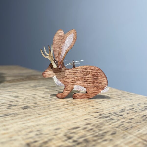 A JACKALOPE ORNAMENT - 2022 with antlers sitting on top of a wooden table.