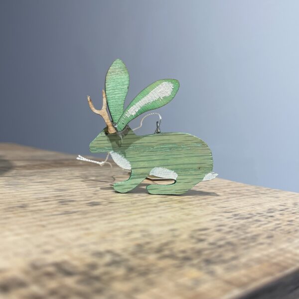 A JACKALOPE ORNAMENT - 2022 on a wooden table.