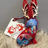 A red felt 2023 JACKALOPE ORNAMENT with antlers on it.