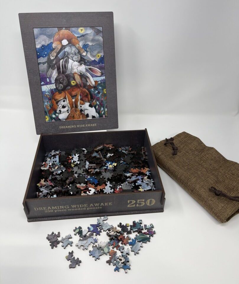 A 250 PIECE WOODEN PUZZLE - "Dreaming Wide Awake" in a box with a picture on it.