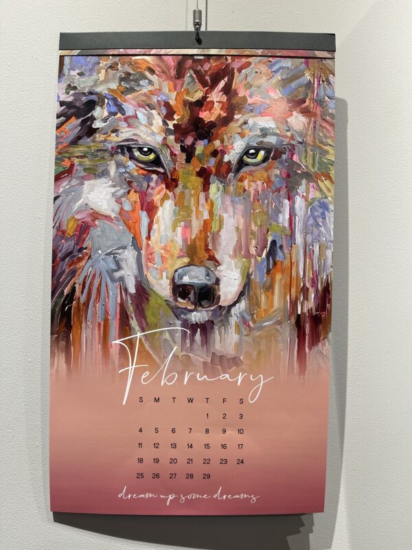 Colorful wolf painting on a Ringholz Calendar 2024 hanging on a wall.